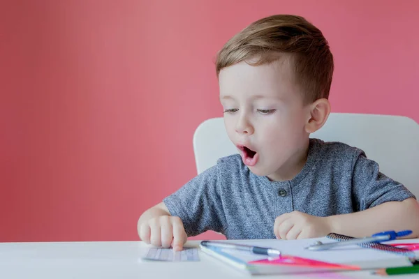 Retrato de niño lindo en casa haciendo tarea. Pequeño concent —  Fotos de Stock