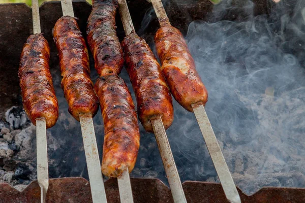 Salsiccia alla griglia sulla griglia fiammeggiante picnic — Foto Stock