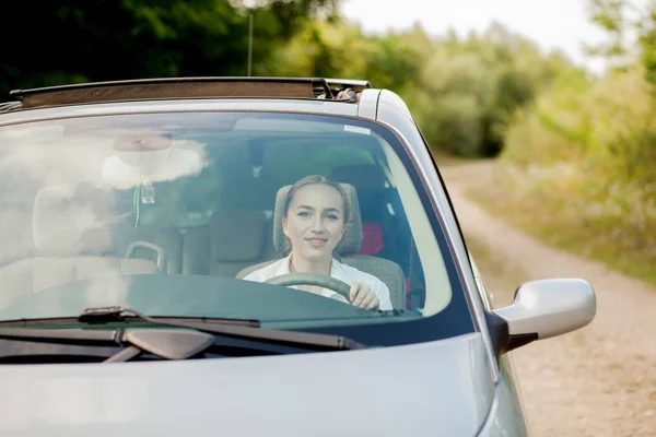 Ritratto sparato attraverso il parabrezza di bella donna in auto — Foto Stock