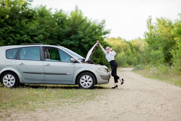 Young woman by the roadside after her car has broken down She op — Stock Photo, Image