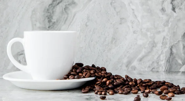 Black coffee in cup and coffee beans on marble background. Top view, space for text — Stock Photo, Image