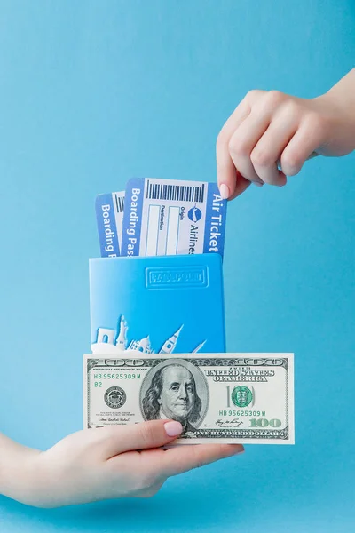 Reisepass, Dollars und Flugticket in der Hand einer Frau auf blauem Rücken — Stockfoto