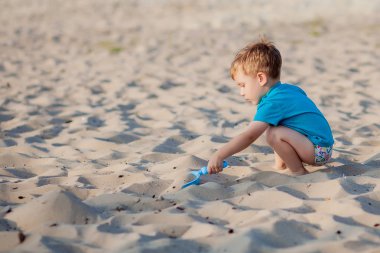 Sahilde oynayan bir çocuk. Çocuk yaz tatilinde denizde oynuyor.