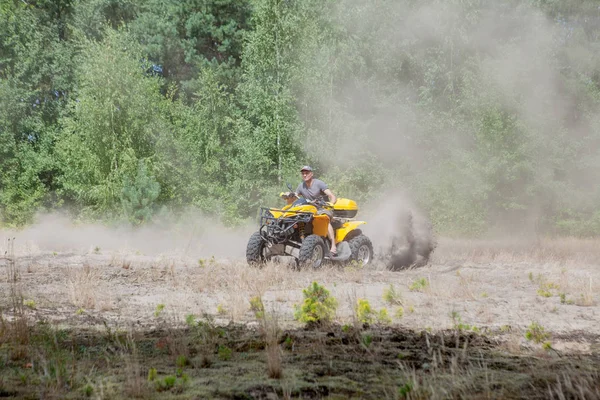Az ember egy sárga quad ATV quadozás minden terepjáróval a homokos — Stock Fotó