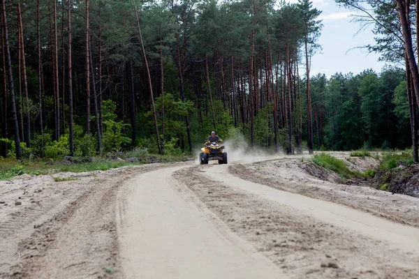 Man naik quad kuning ATV semua kendaraan medan di hutan berpasir. Gerakan olahraga ekstrim, petualangan, atraksi turis . — Stok Foto