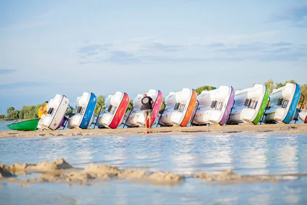 Ułożone katamarany na jeziorze. Jasne kolorowe rowery wodne na plaży nad jeziorem — Zdjęcie stockowe