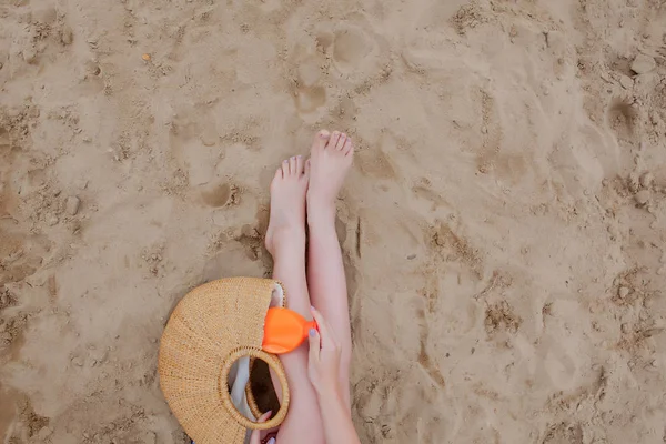 Κορίτσι λάδι σπρέι μαυρίσματος της προστασίας των ποδιών από τις ακτίνες UV του ήλιου βάζοντας αντηλιακή λοσιόν αντιηλιακό μη αναγνωρίσιμο κορίτσι με την παραλία της βασικά για μια καλοκαιρινή διακοπές. — Φωτογραφία Αρχείου