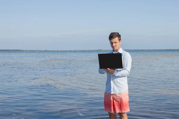 Mannelijke zakenman met een laptop in het water. Freelance werk concept — Stockfoto