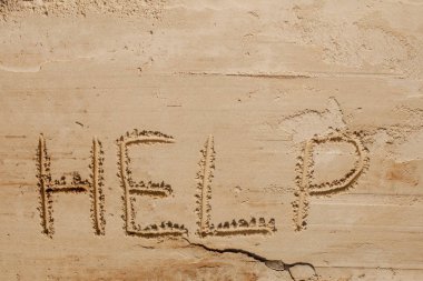 Kumun üzerindeki yazıda bana yardım et. Lütfen bana yardım et. Tropik bir plajda