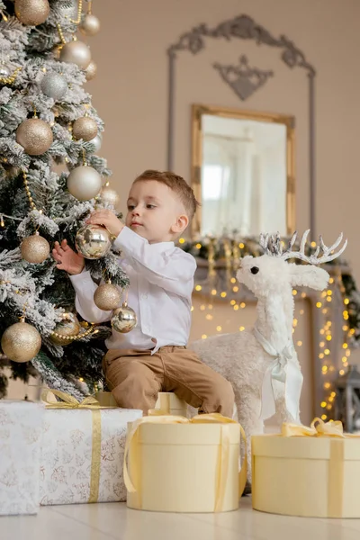 Menino decora uma árvore de Natal para o Natal — Fotografia de Stock