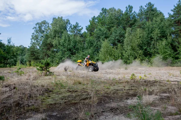 Man naik quad kuning ATV semua kendaraan medan di hutan berpasir. Gerakan olahraga ekstrim, petualangan, atraksi turis . — Stok Foto