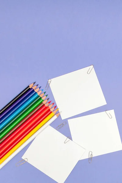 Hoja en blanco de papeles y lápices de color sobre fondo violeta para Proyectos y Anuncios, espacio de copia — Foto de Stock