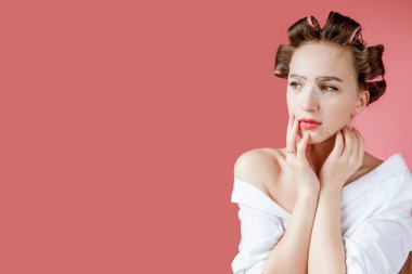 Yüzüne dokunmadan bir maske ve curlers ile güzel genç kız.