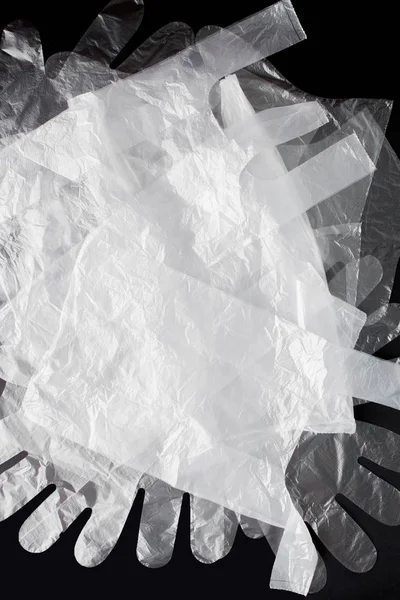 Plastpåse med handtag, handskar, på svart bakgrund. Begagnade p — Stockfoto