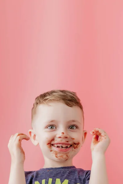Little boy eating chocolate. Cute happy boy smeared with chocola — Stock Photo, Image