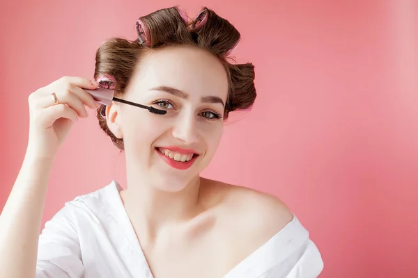 Agradável alegre jovem a menina no frisador pinta uma sobrancelha em — Fotografia de Stock