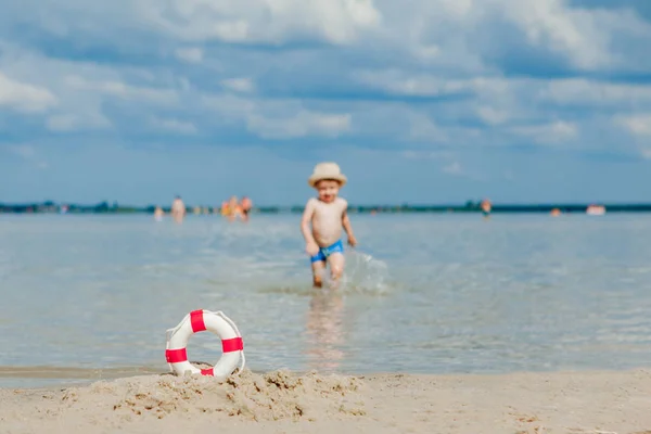 Primer plano de Lifebuoy en la playa sobre fondo de bebé. Seguridad en — Foto de Stock