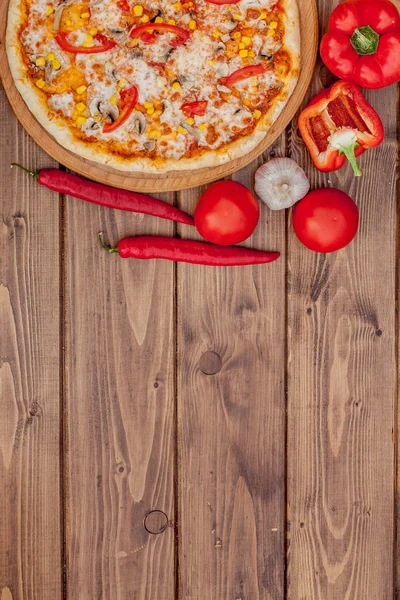 Pizza y vino tinto sobre fondo de mesa de madera. Vista superior con espacio de copia — Foto de Stock