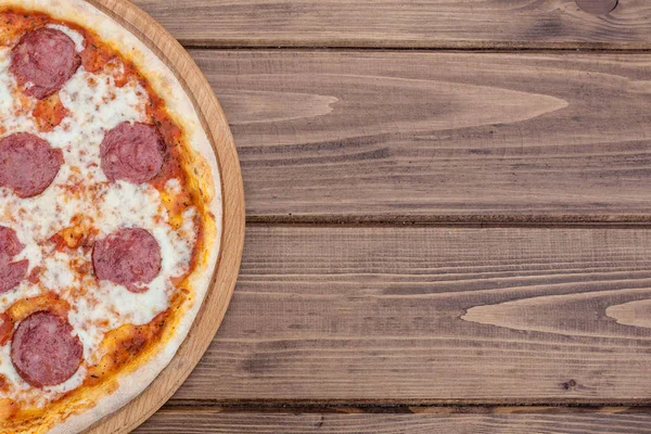 Koyu ahşap arka plan üzerinde salam ile İtalyan Pepperoni pizza