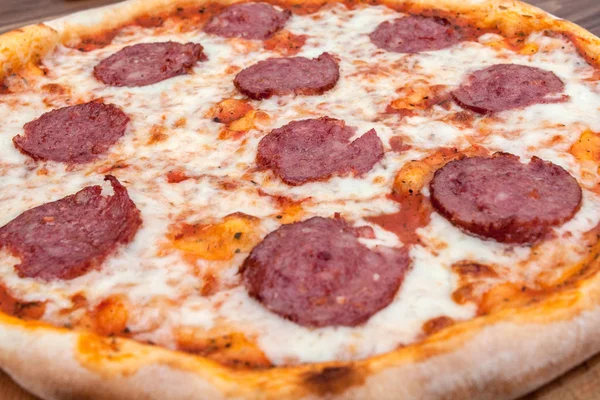 Koyu ahşap arka plan üzerinde salam ile İtalyan Pepperoni pizza