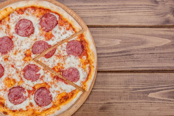 Koyu ahşap arka plan üzerinde salam ile İtalyan Pepperoni pizza