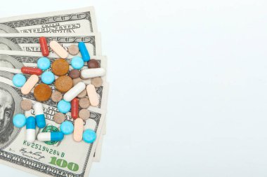 renkli tıbbi haplar ve beyaz bir backgrou üzerinde Amerikan doları