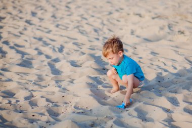 Sahilde oynayan bir çocuk. Çocuk yaz tatilinde denizde oynuyor.