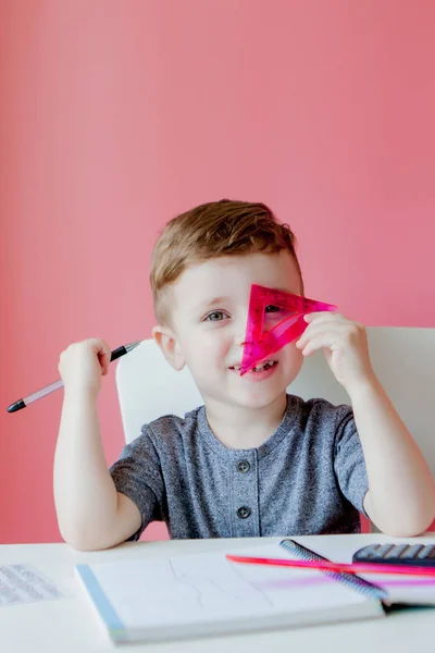 Retrato de niño lindo en casa haciendo tarea. Pequeño concent —  Fotos de Stock