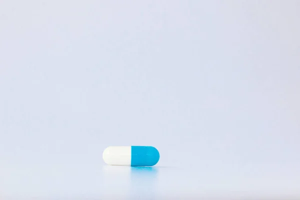 Vista macro de la píldora cápsula azul aislada sobre fondo blanco — Foto de Stock
