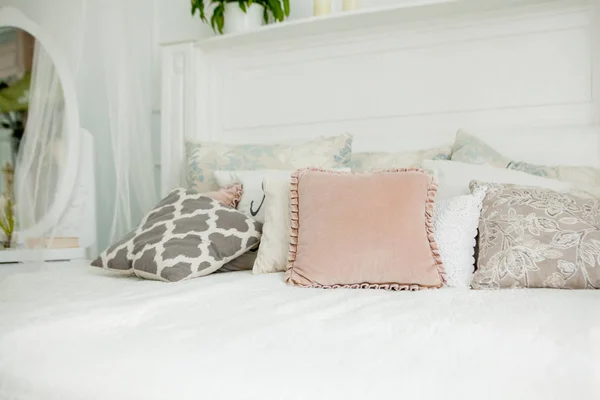 Skandináv stílusú fehér hálószoba. Négy párna van az ágyon. Modern enteriőr — Stock Fotó