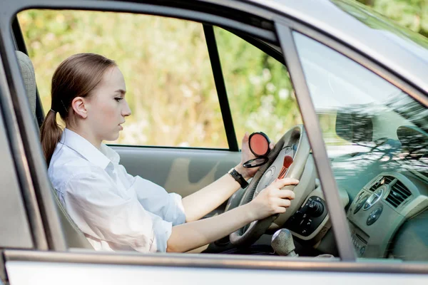 Immagine di una giovane donna d'affari che si trucca mentre guida un'auto — Foto Stock