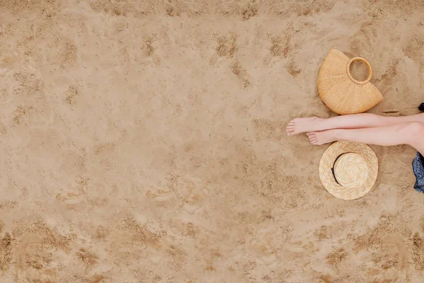 Kvinna garvade ben, stråhatt och påse på sandstrand. Travel conce — Stockfoto