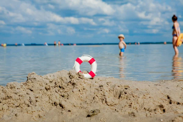 Primer plano de Lifebuoy en la playa sobre fondo de bebé. Seguridad en el agua . — Foto de Stock