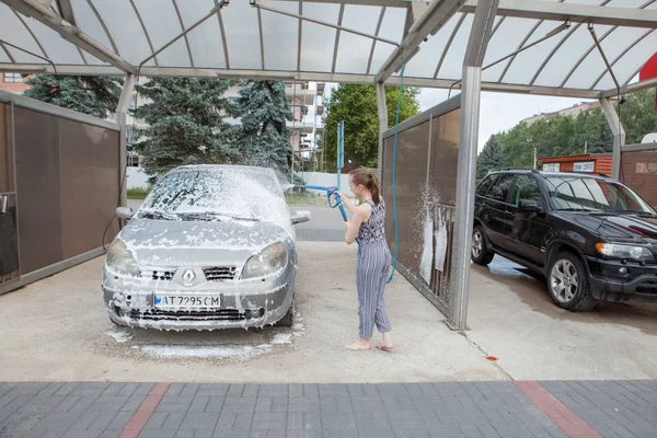 Kiev, Ukrayna- 15 Mayıs 2019 Kova ve bez yıkama kırmızı araba ile genç kadın