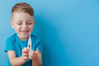 Bir termomether ile hasta küçük çocuk, onun yüksekliği ölçme