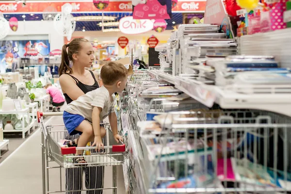 Kijów-Jan 6, 2019: mały chłopiec wybiera zaopatrzenie szkolne z matką w sklepie papierniczym — Zdjęcie stockowe