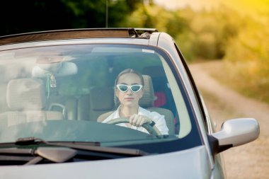 Arabadaki güzel kadının ön camından çekilen portre.