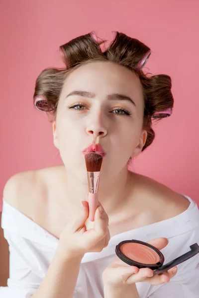 Eyeliner Eye Make-up Schönheitspflegerin. Mädchen, das Augenbleistiftfarbe auf Augen legt, die in einen Taschenspiegel schauen und glücklich auf rosa Hintergrund lächeln. — Stockfoto