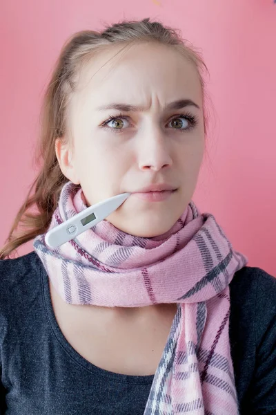Grippe fría grippe. Mujer con alta temperatura. Niña enferma con fiebre comprobando termómetro de mercurio sobre fondo rosa . —  Fotos de Stock
