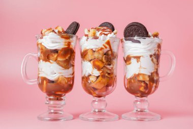 Pembe bsckground, seçici odak ve boş alan üzerinde bisküvi ve krem şanti ile cam tatlı tatlı