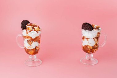 Pembe bsckground, seçici odak ve boş alan üzerinde bisküvi ve krem şanti ile cam tatlı tatlı