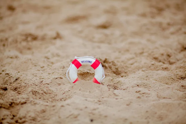 Primer plano de boya salvavidas en miniatura excavado en la arena en la playa — Foto de Stock