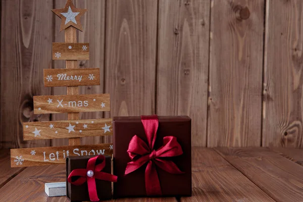 Arbres de Noël avec boîtes cadeaux sur fond en bois, espace de copie — Photo