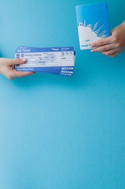 Mavi arka planda kadın el pasaport ve uçak bileti. Trav