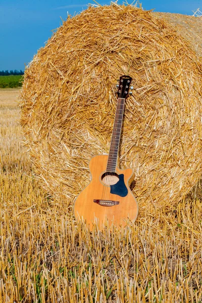 Akustikgitarre liegt in der Nähe einer Kaution von Heu — Stockfoto