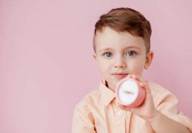 pembe arka plan üzerinde kutusunda halka veren çocuk