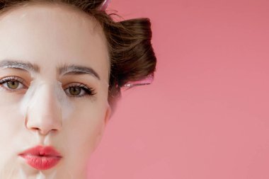 Yüzüne dokunmadan bir maske ve curlers ile güzel genç kız.