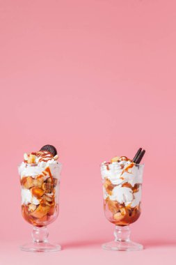 Pembe bsckground, seçici odak ve boş alan üzerinde bisküvi ve krem şanti ile cam tatlı tatlı