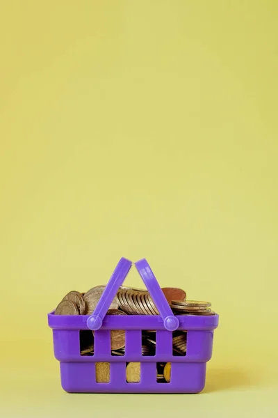 Coins in a shopping basket. Concept of finance and money. an investment in a new project. wealth and poverty. shopping in the shop. yellow background. place for text. copy space. — Stock Photo, Image