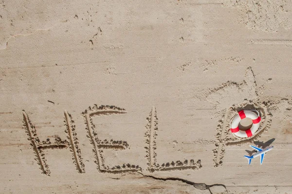 Help me the inscription, plane and lifebuoy on the sand. Please help me. On a tropical beach